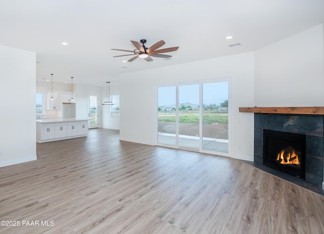 6881 E Bourbon Way, Prescott Valley, AZ 86315 - unfurnished living room with a fireplace, a ceiling fan, light wood finished floors, and recessed lighting
