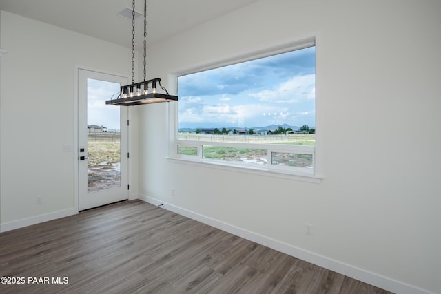 6881 E Bourbon Way, Prescott Valley, AZ 86315 - unfurnished dining area featuring baseboards and wood finished floors
