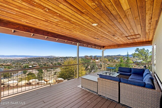 wooden terrace with outdoor lounge area and a mountain view