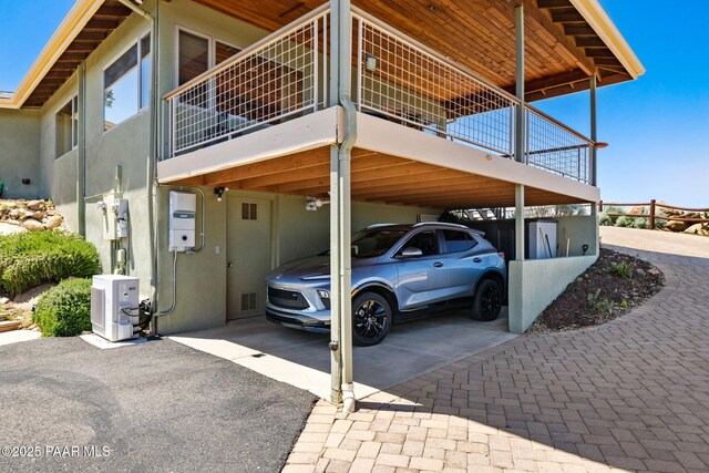 view of parking / parking lot with visible vents, aphalt driveway, and a carport