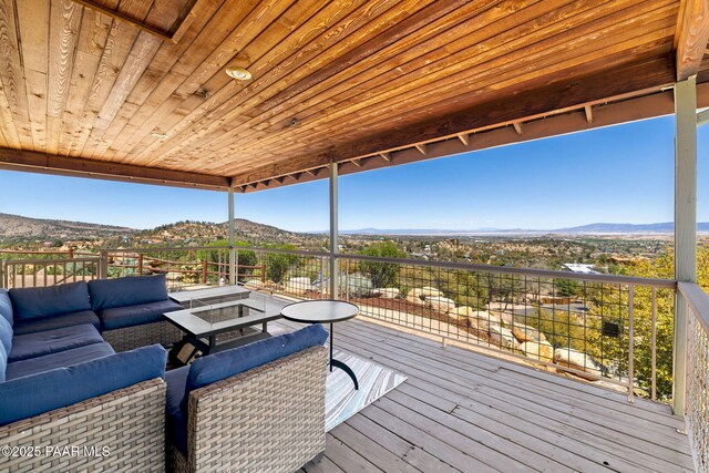 deck with a mountain view and an outdoor living space with a fire pit