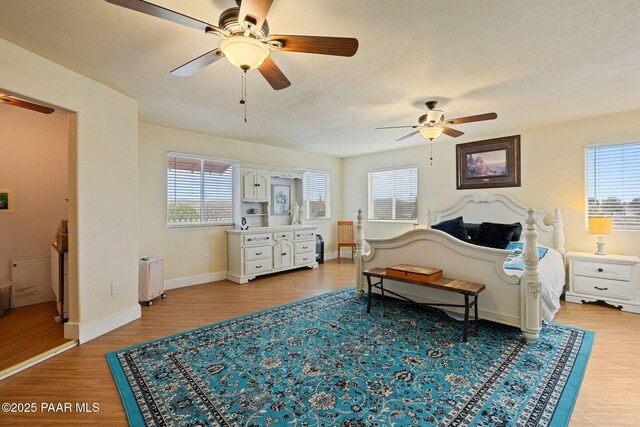 bedroom featuring multiple windows, radiator, and wood finished floors