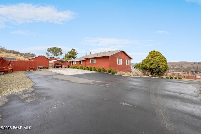 view of front of house featuring driveway and fence