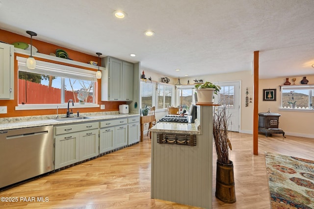 kitchen featuring light wood-style flooring, a healthy amount of sunlight, appliances with stainless steel finishes, and a sink