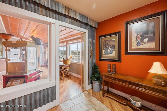 corridor featuring baseboards and wood finished floors