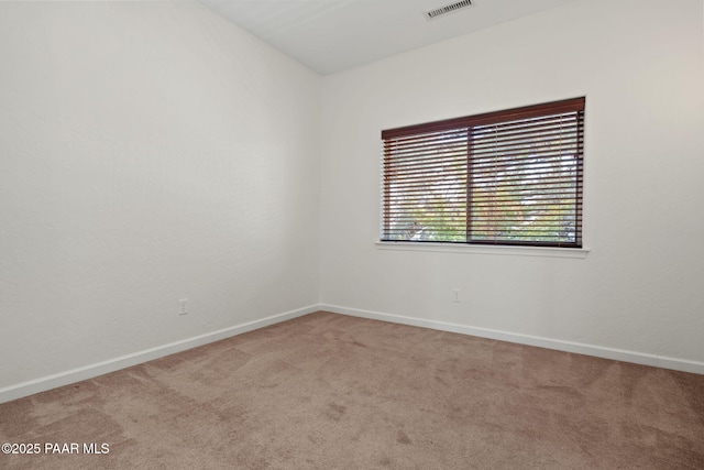 spare room with carpet flooring, baseboards, and visible vents