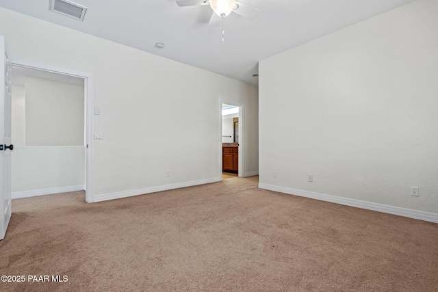 empty room featuring visible vents, light colored carpet, baseboards, and ceiling fan