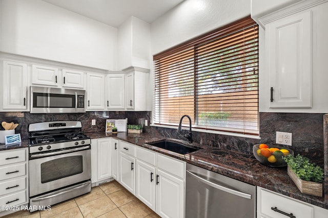 kitchen with decorative backsplash, a sink, white cabinetry, and stainless steel appliances