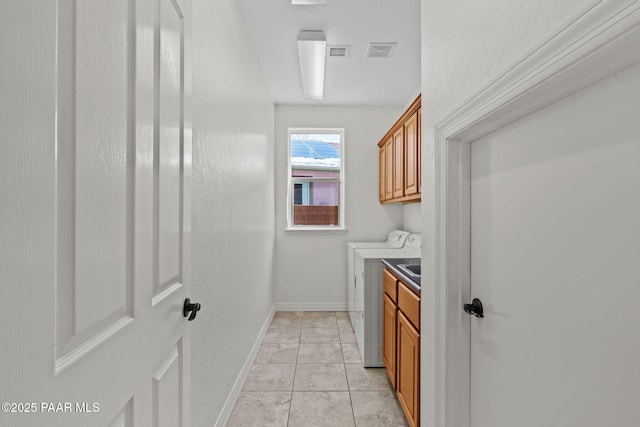 washroom featuring baseboards, light tile patterned floors, visible vents, independent washer and dryer, and cabinet space