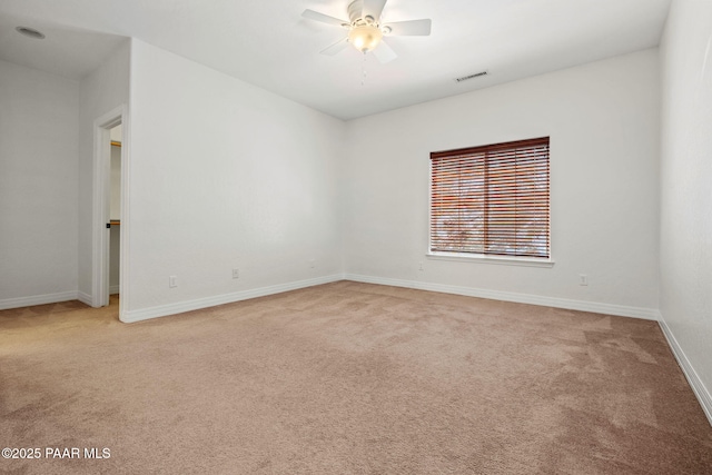 spare room featuring baseboards, light colored carpet, ceiling fan, and visible vents