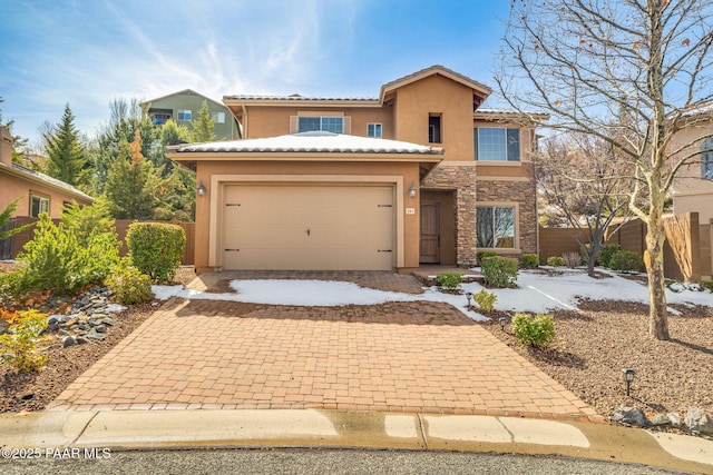 view of front of property with stucco siding, stone siding, decorative driveway, an attached garage, and a tiled roof