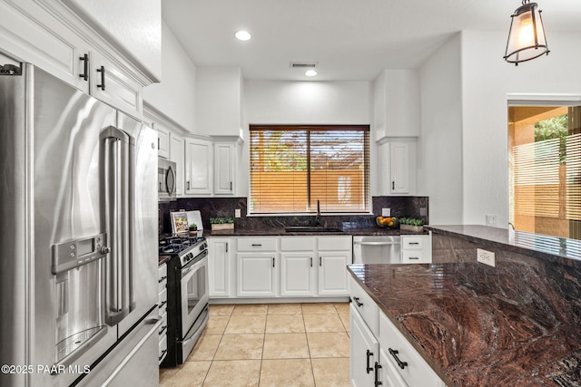 kitchen featuring tasteful backsplash, white cabinetry, visible vents, appliances with stainless steel finishes, and a sink