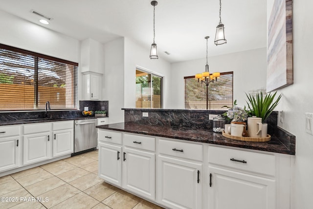 kitchen featuring an inviting chandelier, pendant lighting, decorative backsplash, dishwasher, and a sink