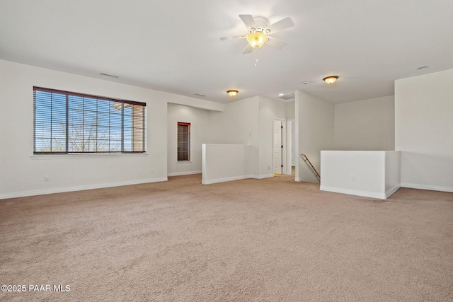 empty room with light carpet, visible vents, baseboards, and ceiling fan