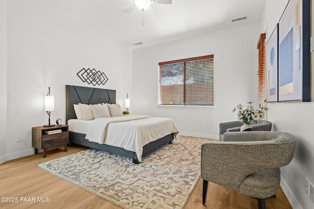 bedroom with visible vents, baseboards, a ceiling fan, and wood finished floors