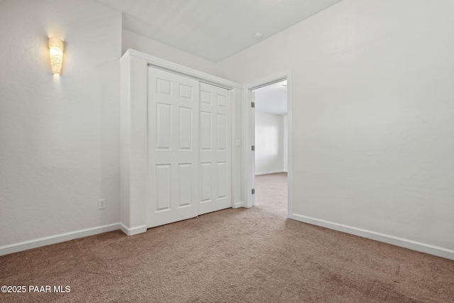 spare room featuring carpet and baseboards