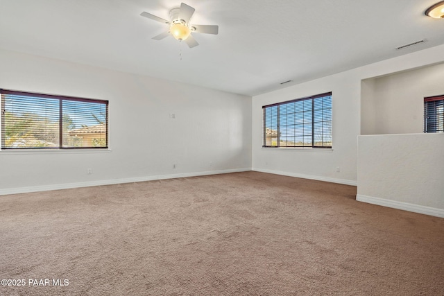 carpeted empty room featuring visible vents, ceiling fan, and baseboards