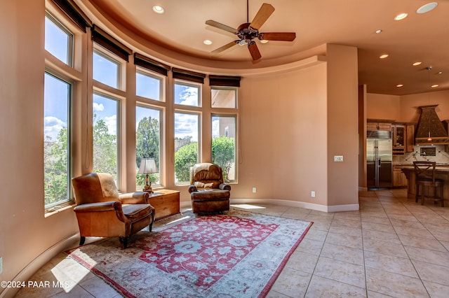 sitting room featuring light tile patterned floors, a towering ceiling, and ceiling fan