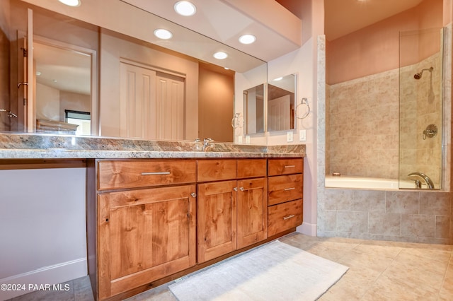 bathroom featuring vanity, tiled shower / bath combo, and tile patterned flooring