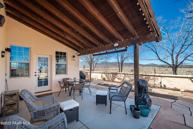 view of patio with outdoor dining space, a mountain view, and an outdoor hangout area