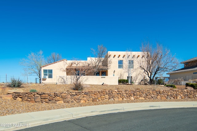 view of front of house with fence and stucco siding