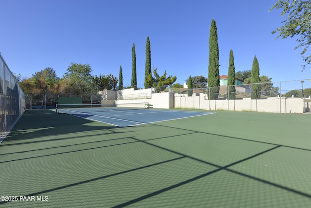 view of tennis court featuring fence