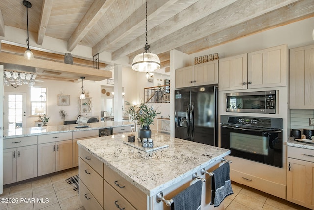 kitchen featuring a kitchen island, light stone countertops, beam ceiling, light tile patterned flooring, and black appliances