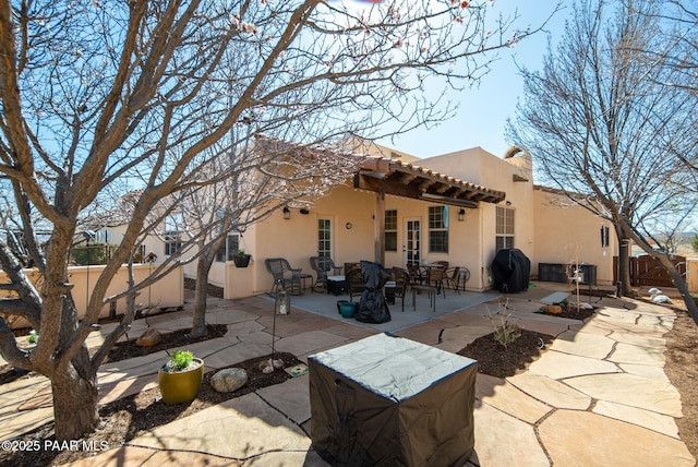 rear view of house featuring a patio area, stucco siding, a tiled roof, and fence