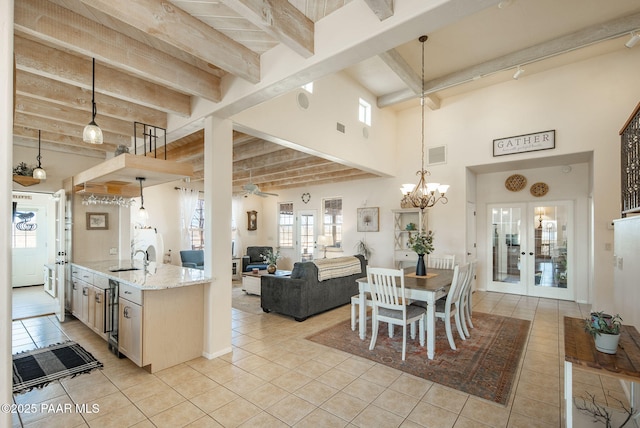 kitchen with light stone counters, light tile patterned floors, beam ceiling, french doors, and decorative light fixtures