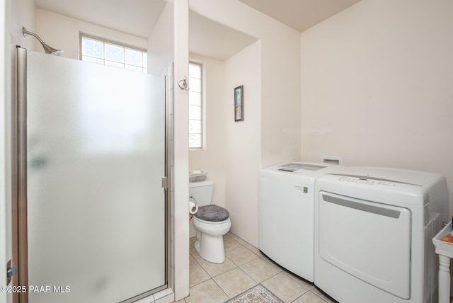 full bath with washer and clothes dryer, tile patterned floors, a stall shower, and toilet