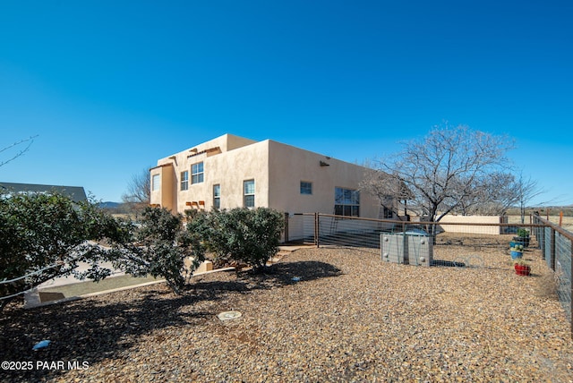 view of side of property with fence and stucco siding