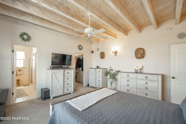 bedroom with a walk in closet, beamed ceiling, carpet floors, wooden ceiling, and tile patterned floors