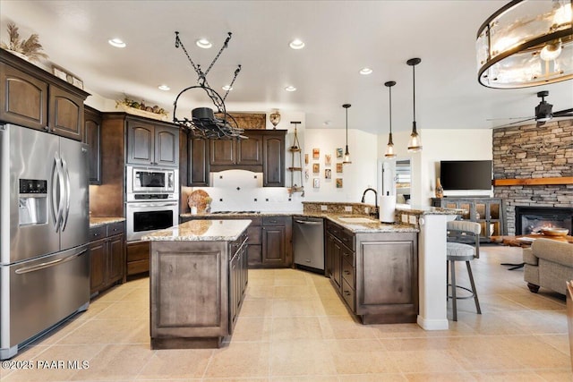 3000 Noble Star Dr, Prescott, AZ 86301 - kitchen with a peninsula, dark brown cabinets, appliances with stainless steel finishes, a sink, and open floor plan