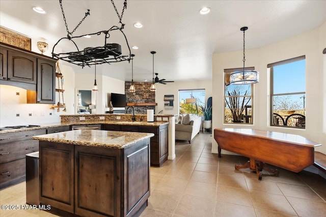 3000 Noble Star Dr, Prescott, AZ 86301 - kitchen featuring light stone countertops, dark brown cabinetry, a peninsula, open floor plan, and decorative backsplash