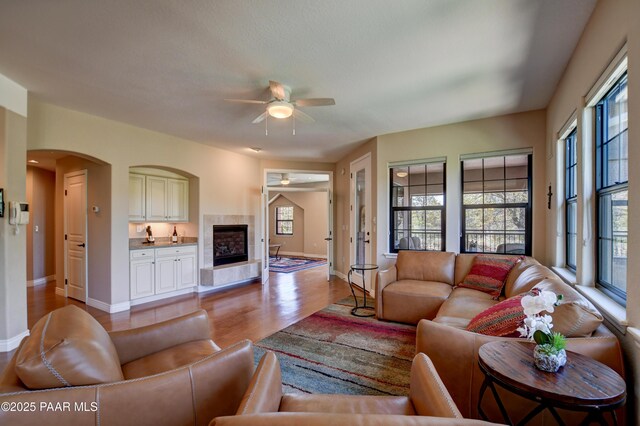 1716 Alpine Meadows Ln Unit 1402, Prescott, AZ 86303 - living room featuring ceiling fan, baseboards, light wood-style floors, and a tiled fireplace