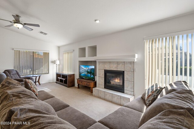 living room with a fireplace, light colored carpet, ceiling fan, and lofted ceiling