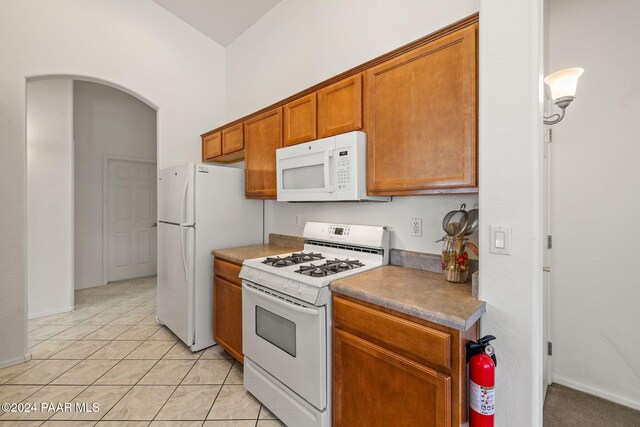 kitchen featuring white appliances and light tile patterned flooring