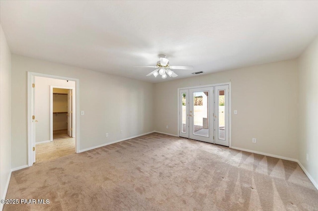 empty room with ceiling fan and light carpet