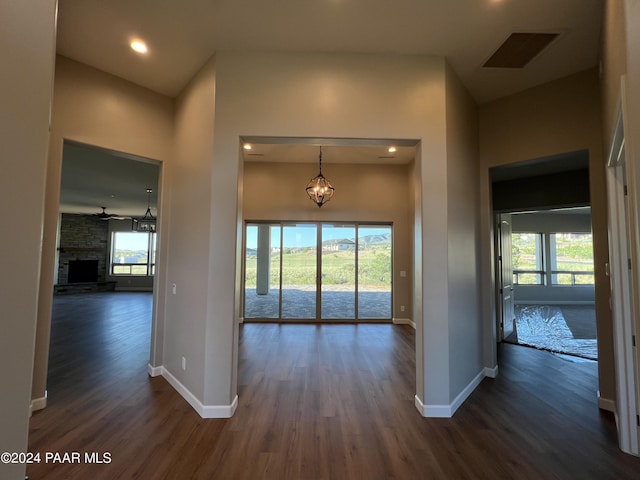 corridor with a healthy amount of sunlight and dark hardwood / wood-style flooring