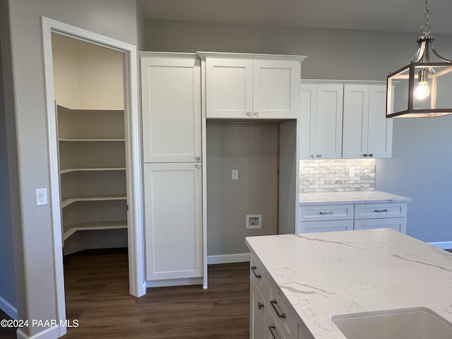 kitchen featuring pendant lighting, light stone countertops, tasteful backsplash, dark hardwood / wood-style flooring, and white cabinetry