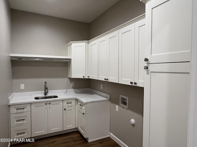 washroom featuring dark hardwood / wood-style flooring, cabinets, sink, and washer hookup