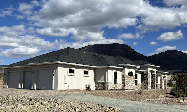 view of side of home with a mountain view and a garage