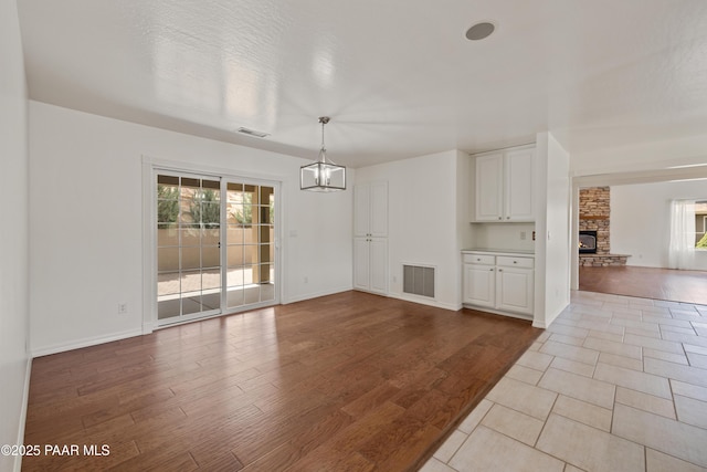2635 Tolemac Way, Prescott, AZ 86305 - unfurnished dining area with visible vents, baseboards, a notable chandelier, and a large fireplace