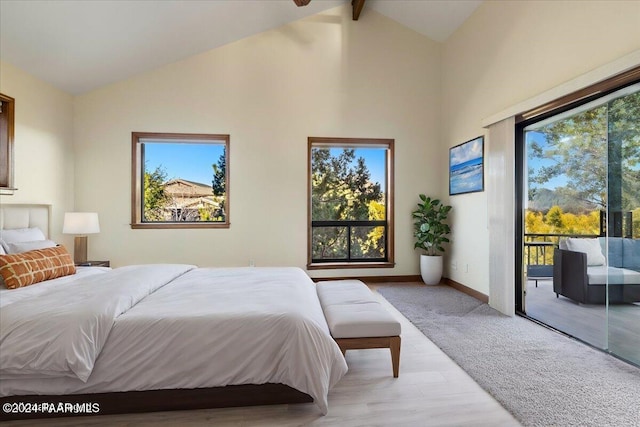 bedroom featuring access to exterior, beam ceiling, light wood-type flooring, and multiple windows