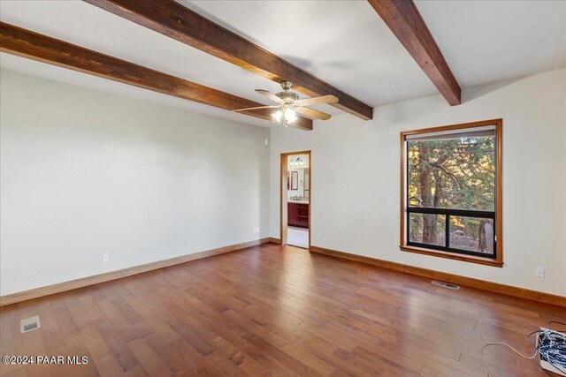 empty room with hardwood / wood-style floors, ceiling fan, and beam ceiling