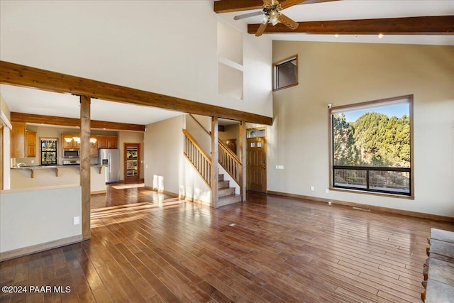 unfurnished living room featuring beamed ceiling, ceiling fan, wood-type flooring, and high vaulted ceiling