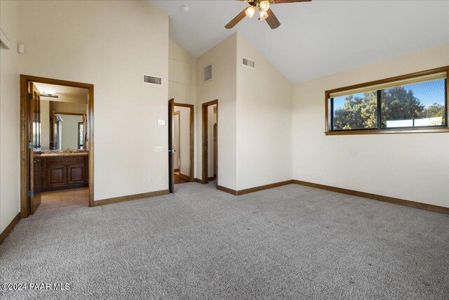 unfurnished bedroom with light colored carpet, high vaulted ceiling, ceiling fan, and ensuite bathroom