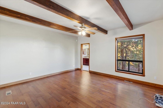 empty room with hardwood / wood-style floors, ceiling fan, and beam ceiling