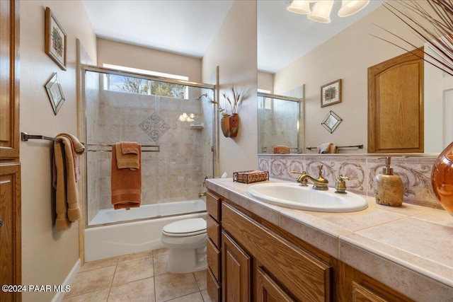 full bathroom featuring bath / shower combo with glass door, vanity, tile patterned floors, and toilet