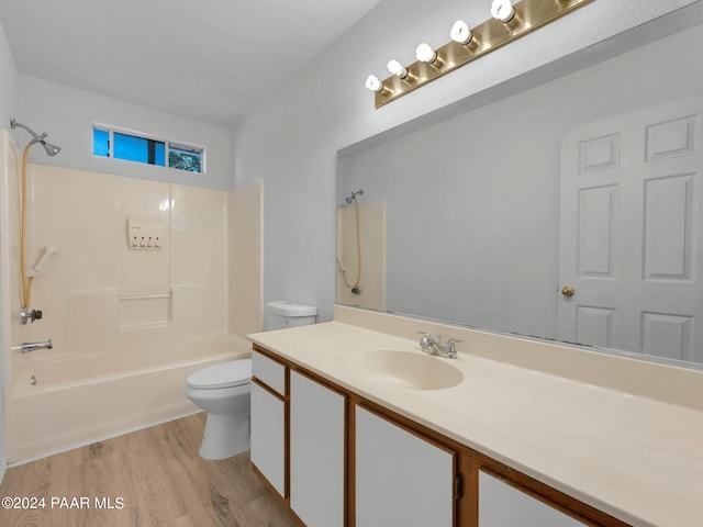 full bathroom featuring hardwood / wood-style floors, vanity, toilet, and washtub / shower combination